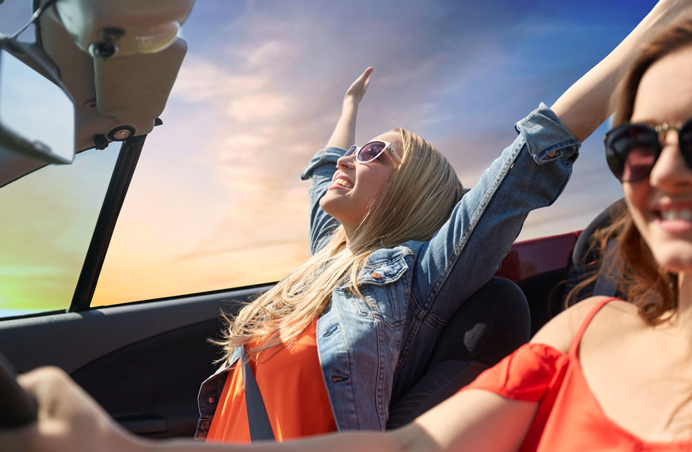 happy-young-women-driving-convertible-car